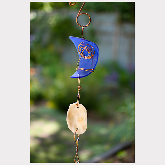 detail, cobalt blue glass with an oyster shell wind chime