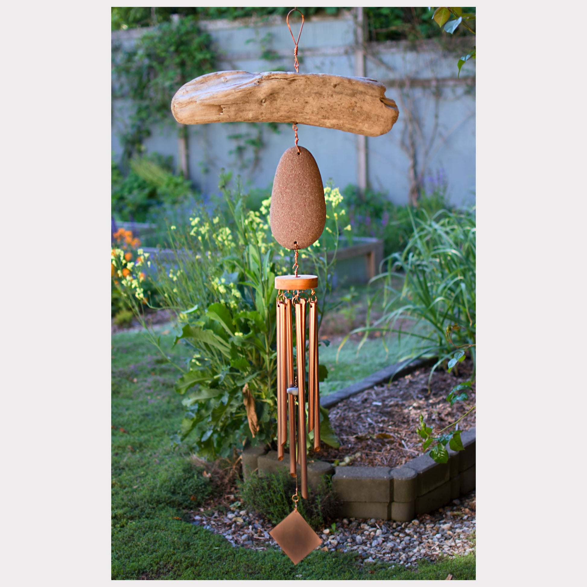 Large handcrafted driftwood and beach stone wind chime with seven copper chimes.