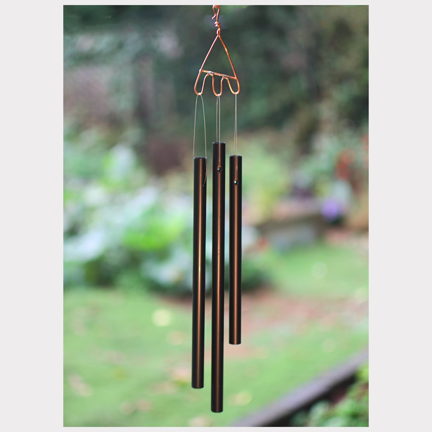 Decorative wind chime with blurred garden background