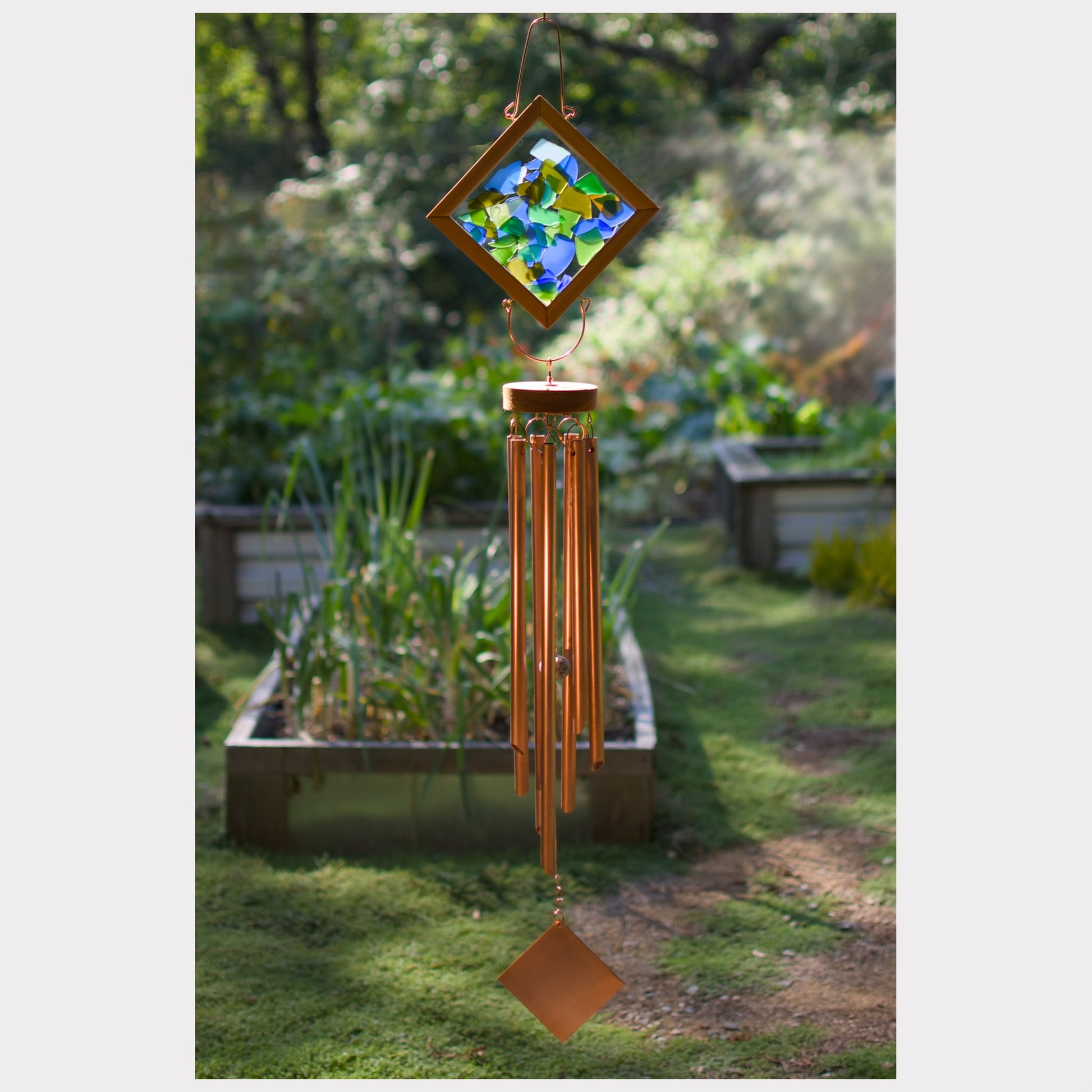 Decorative wind chime with stained glass top in a garden setting