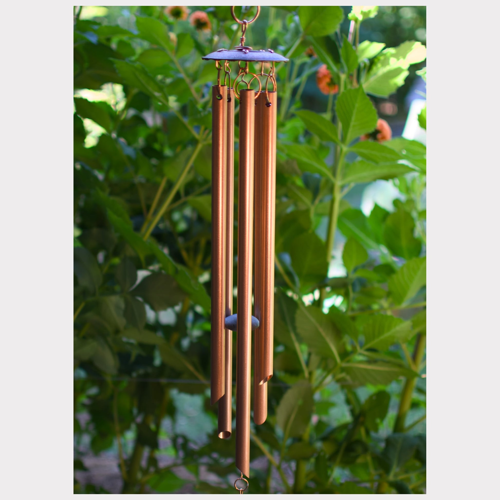 Detail, copper wind chime featuring 5 genuine copper chimes and an antiqued copper colored metal chime holder.