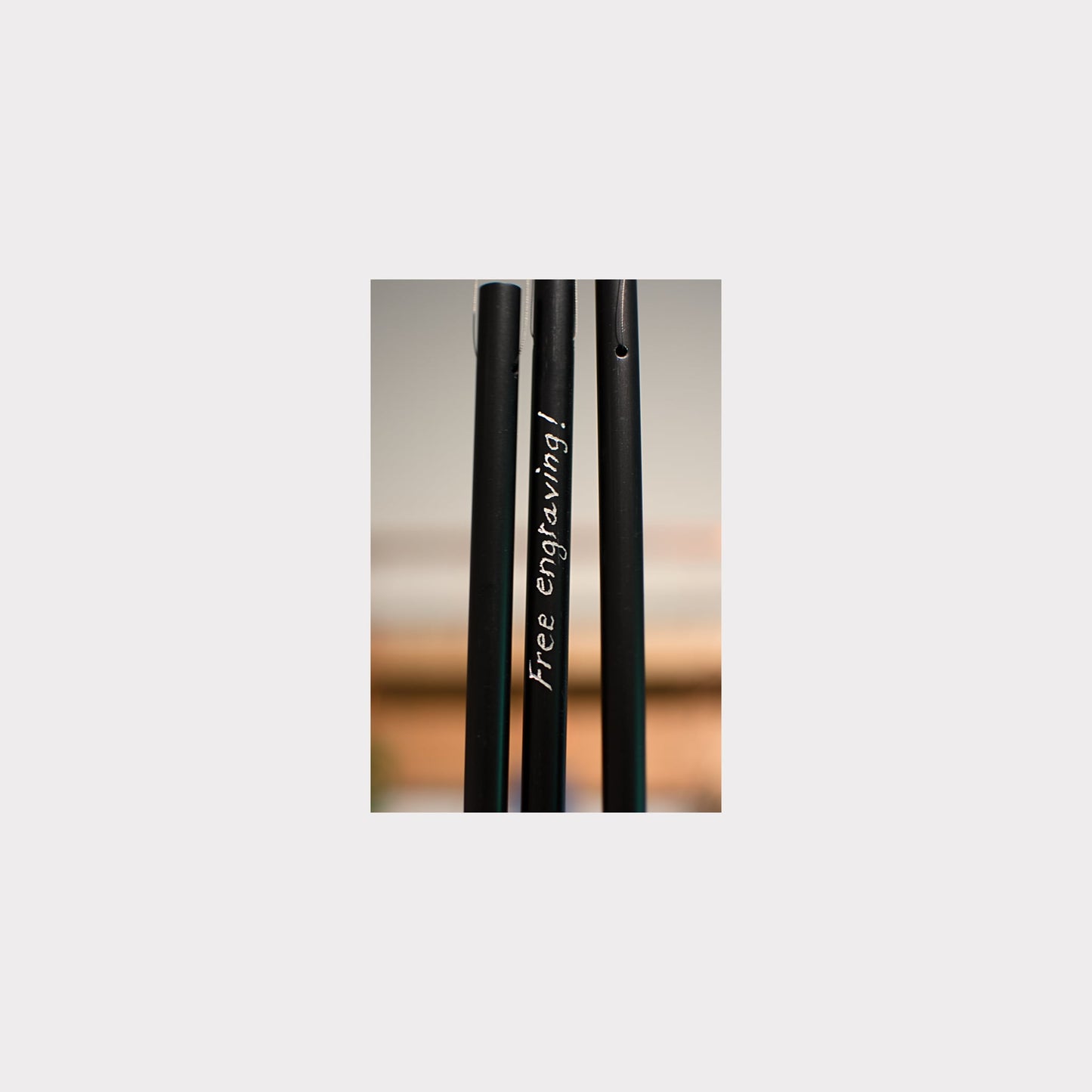 Black metal rod with 'Free engraving!' text on a blurred background