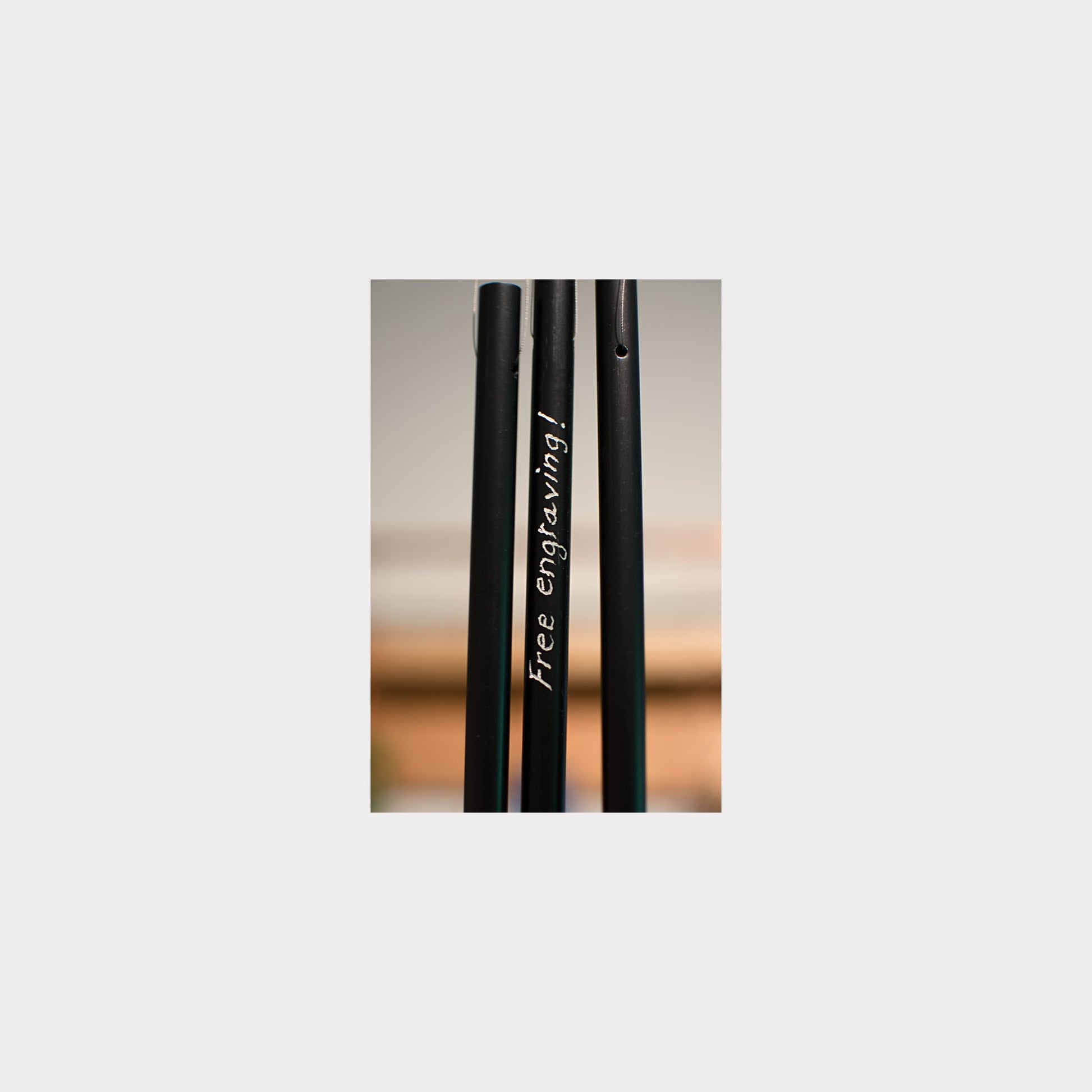 Black metal rod with 'Free engraving!' text on a blurred background