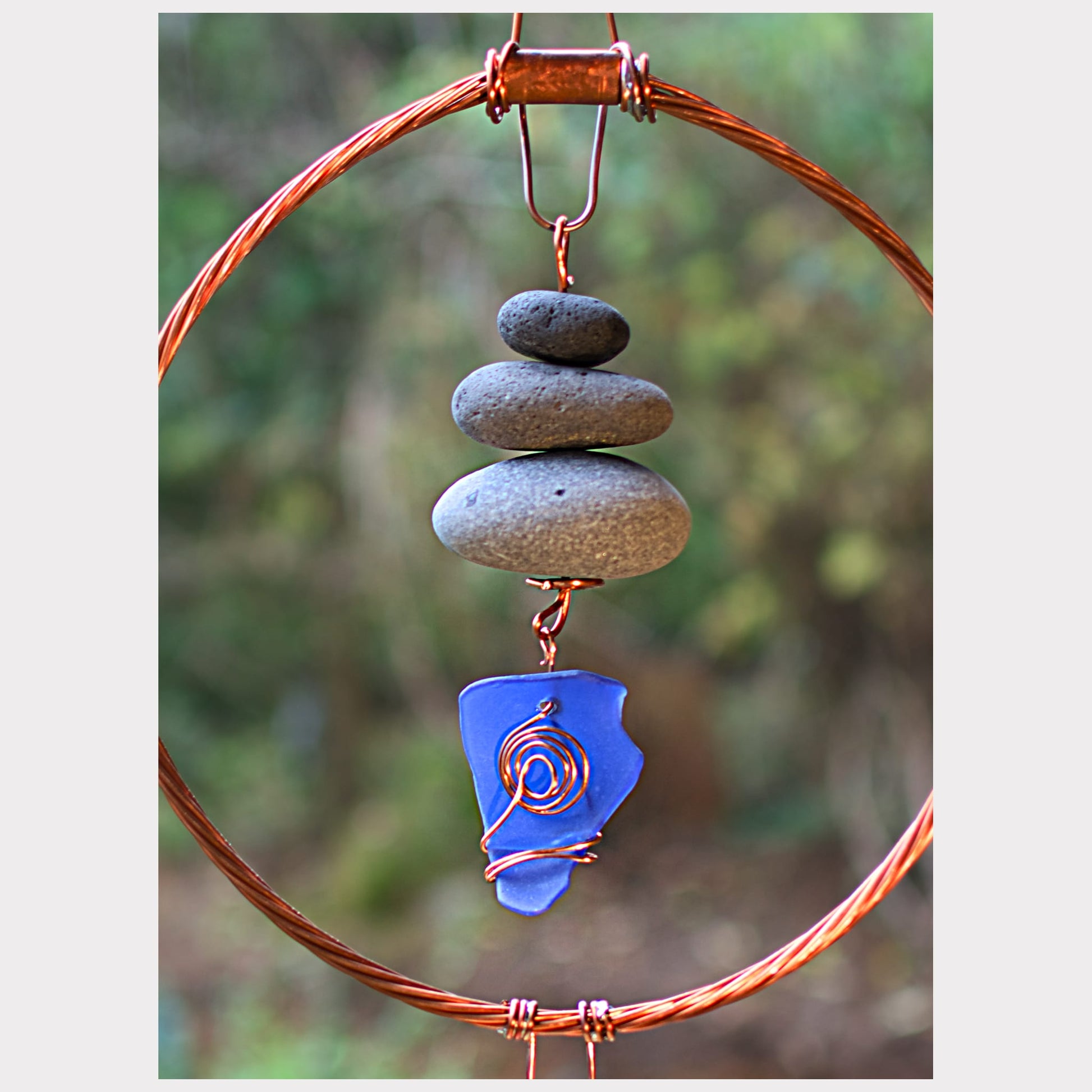 detail, beach stones with blue sea glass wind chime