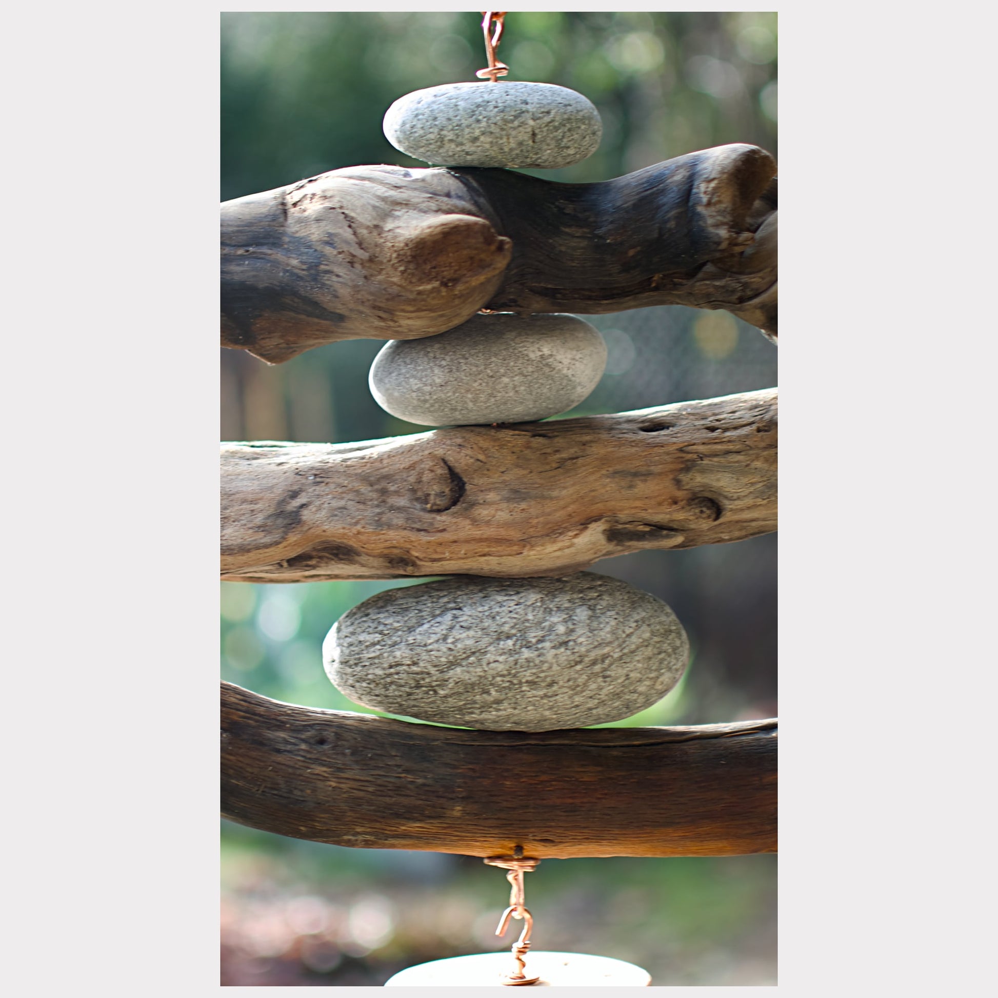 zoom detail, beach stone and driftwood wind chime