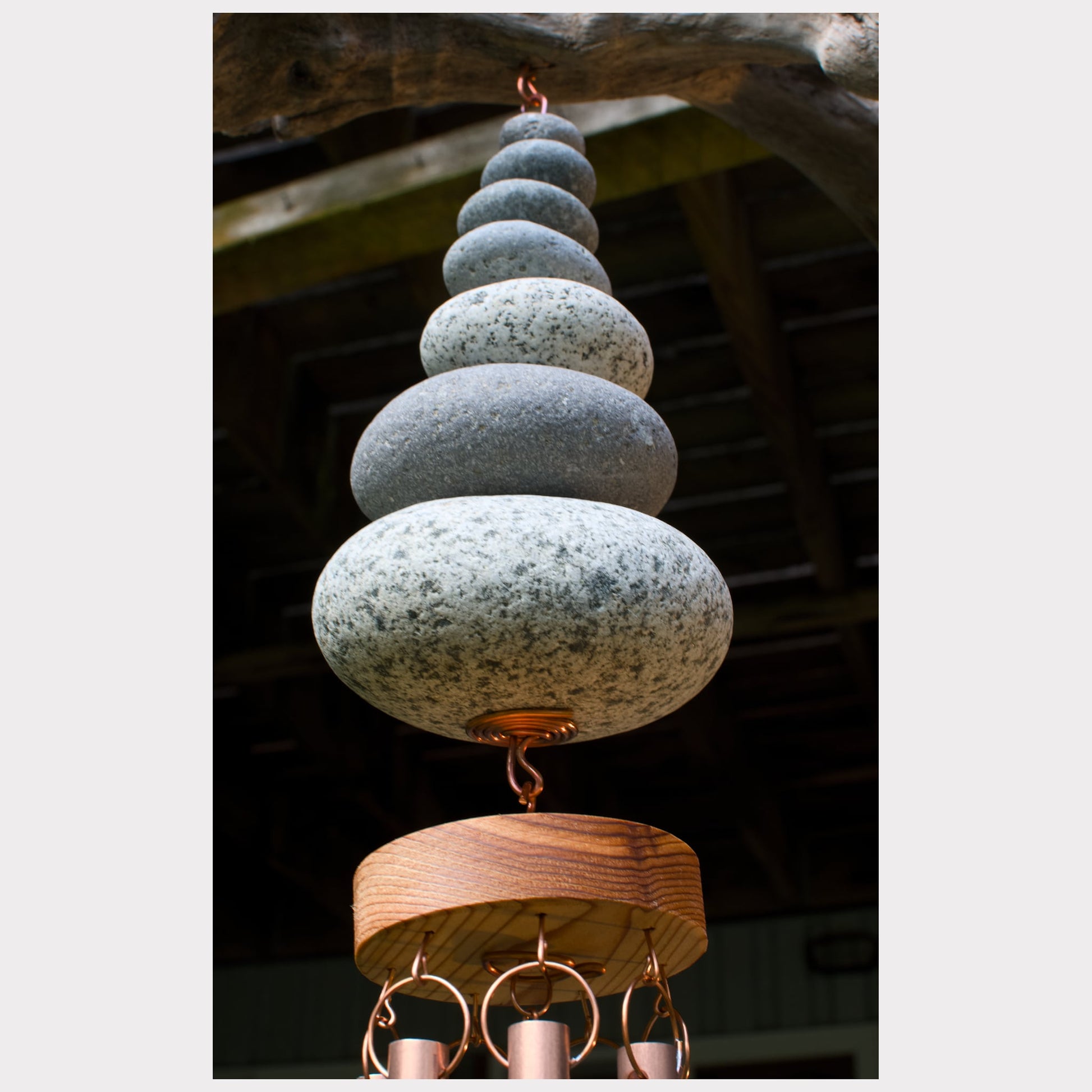 detail, beach stones of a driftwood copper wind chime