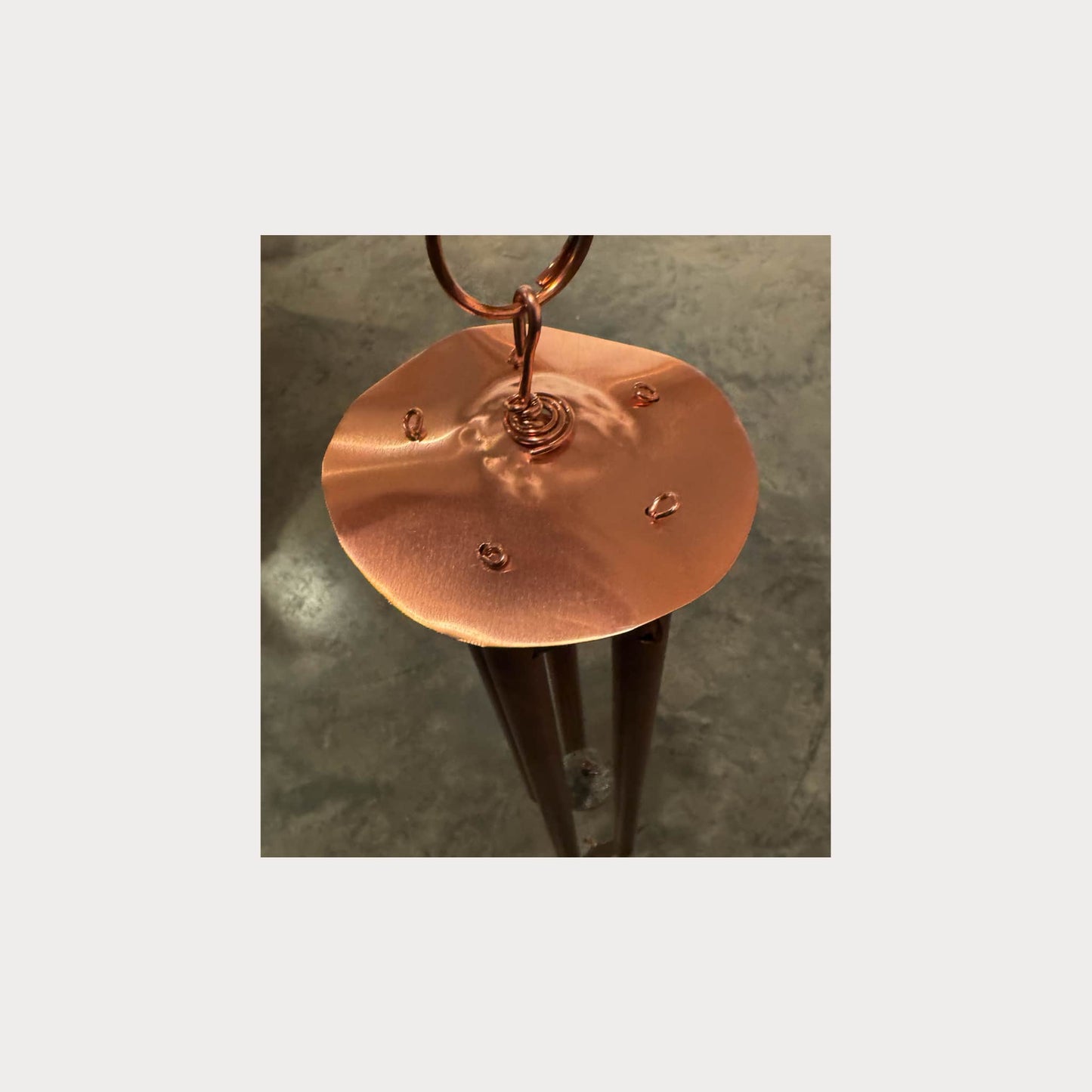 Copper stand with a circular base on a textured surface