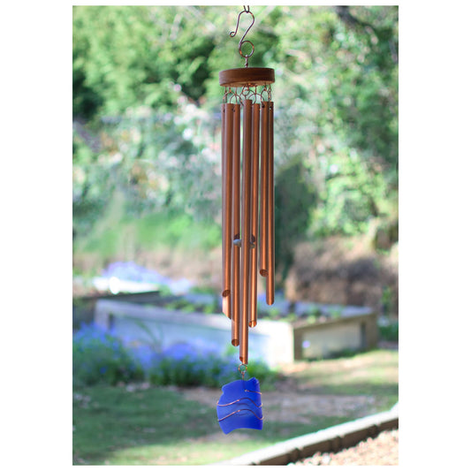 Copper wind chime with a blue accent hanging outdoors.