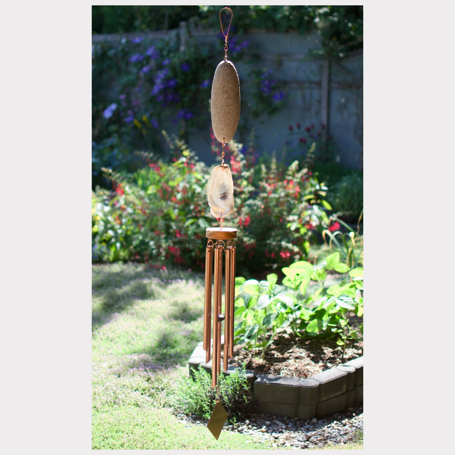 Beach stone and oyster shell wind chime with seven copper chimes.