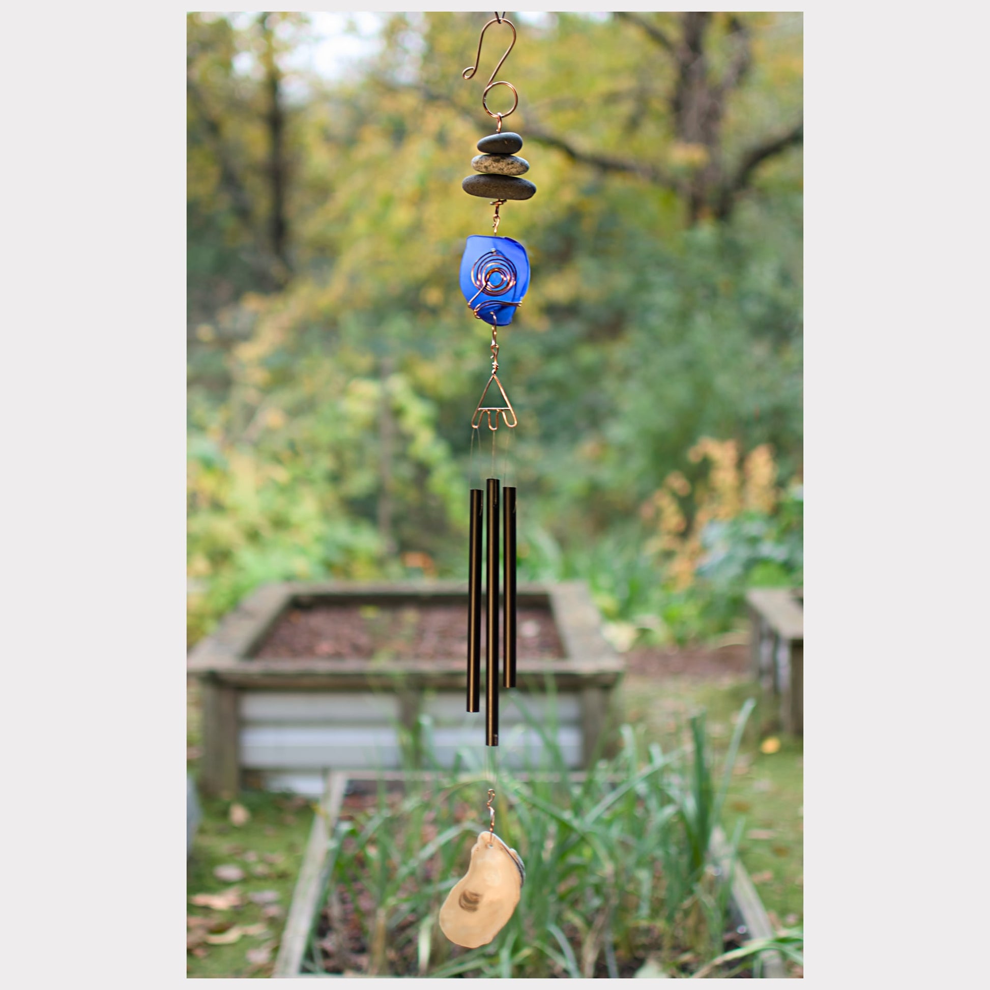 Zen beach stone, sea glass wind chime with three black aluminum chimes and an oyster half shell windsail.