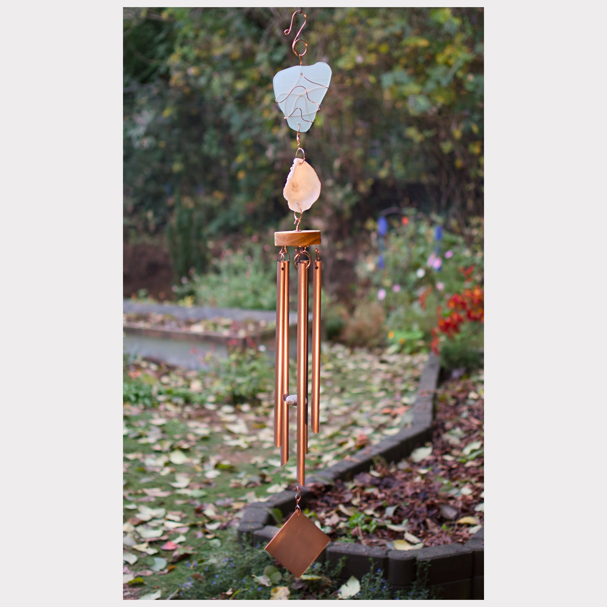 Decorative wind chime with natural elements in a garden setting