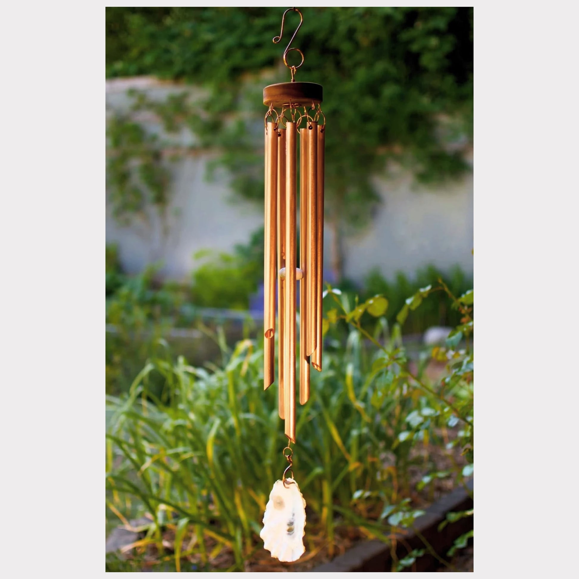 Handcrafted copper wind chime with an oyster shell windsail.