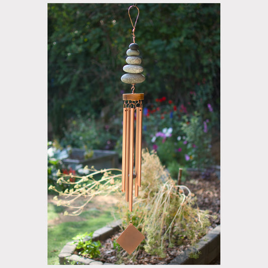Decorative wind chime with stones hanging in a garden setting