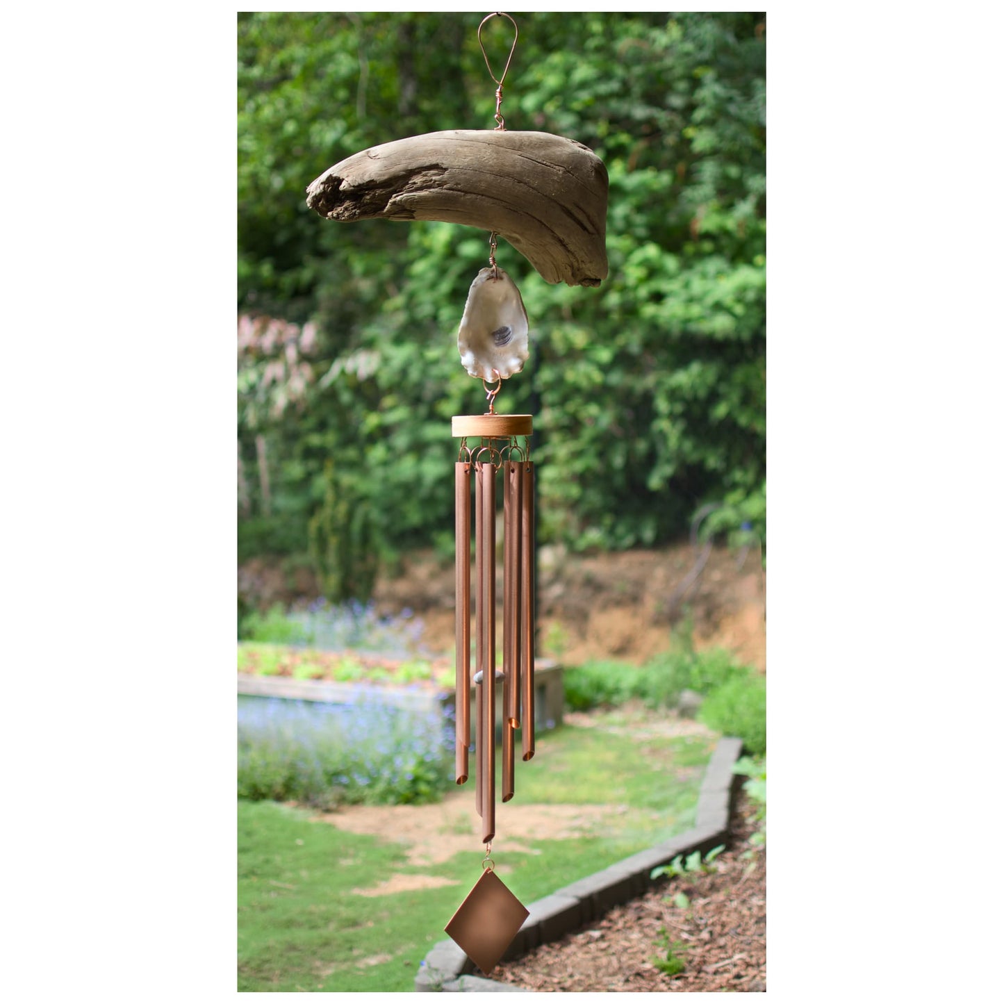 Decorative wind chime with natural elements in a garden setting
