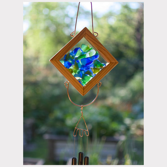 Decorative hanging sun catcher with wooden frame and colorful glass pieces, outdoors.