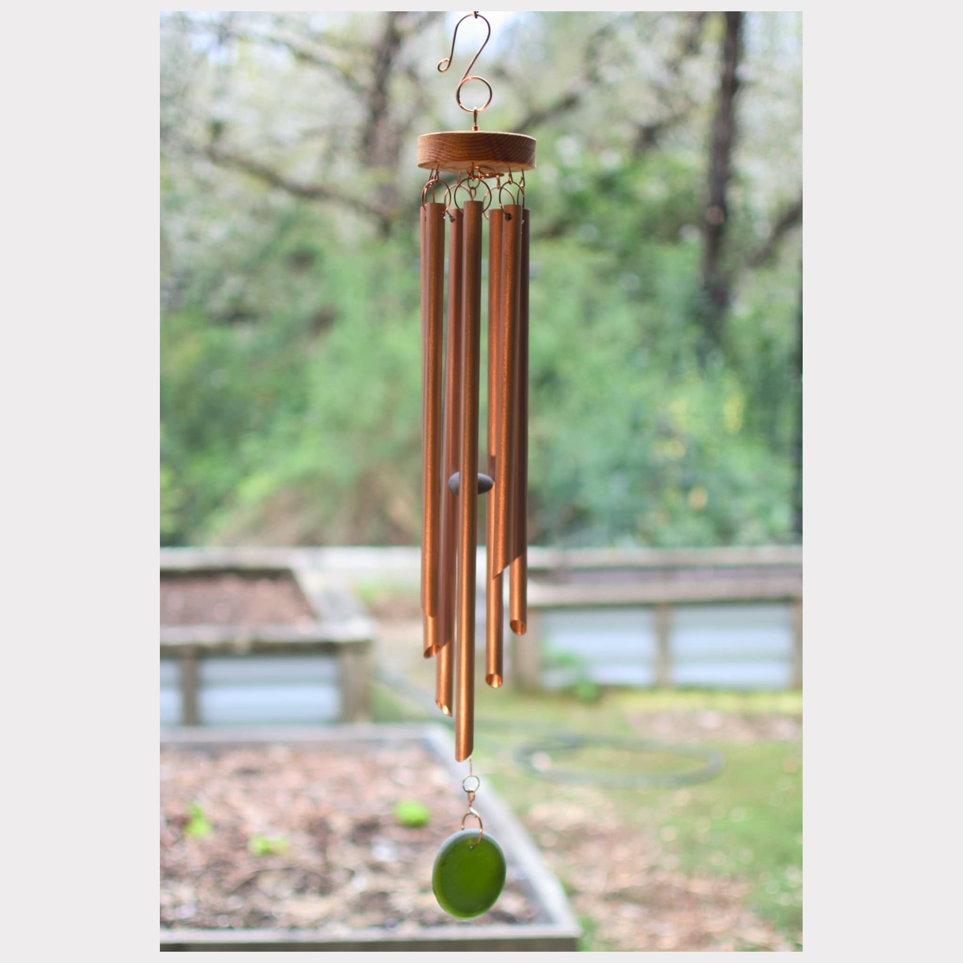 Copper wind chime with a blurred outdoor background