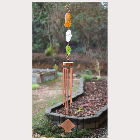 Decorative wind chime with colorful glass on a garden background