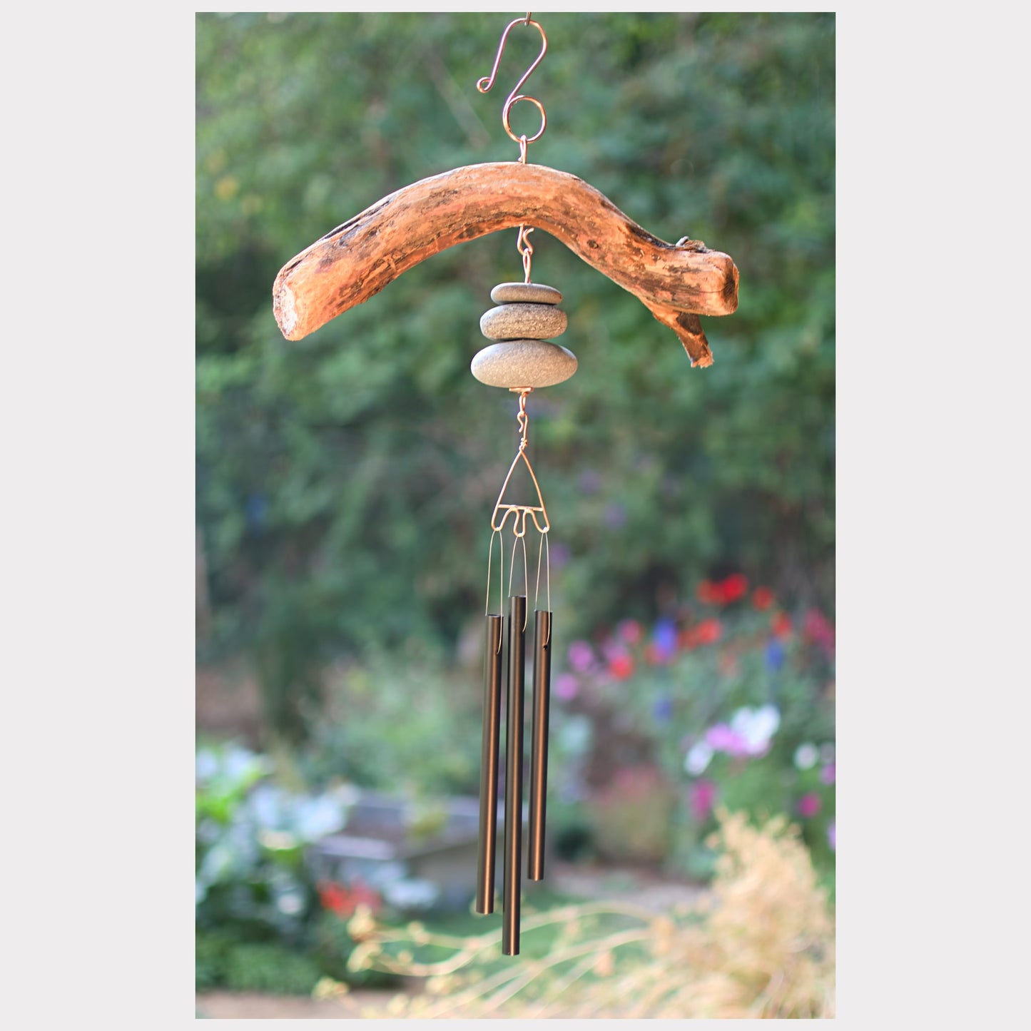 Decorative wind chime with natural elements in a garden setting