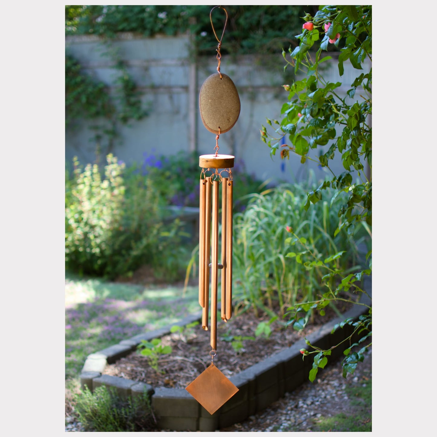 Large zen beach stone wind chime with five copper chimes.