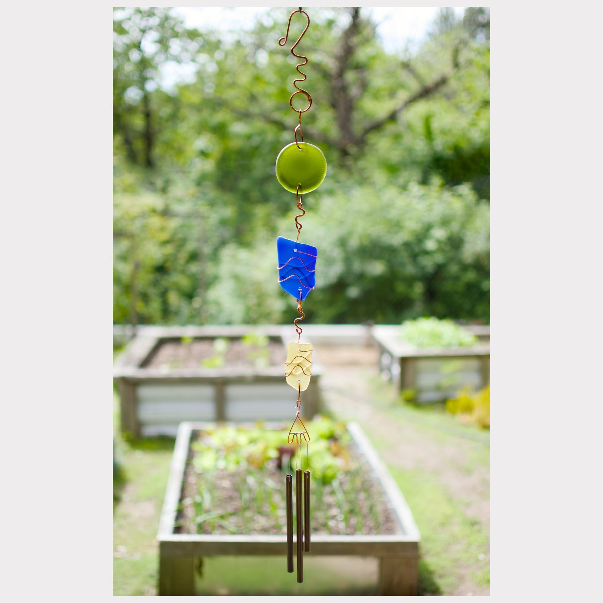 Wind chime featuring artist-made sea glass and three antiqued brass chimes.