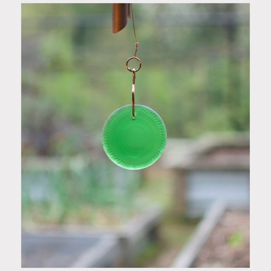 Detail, light green glass windsail for a copper wind chime.