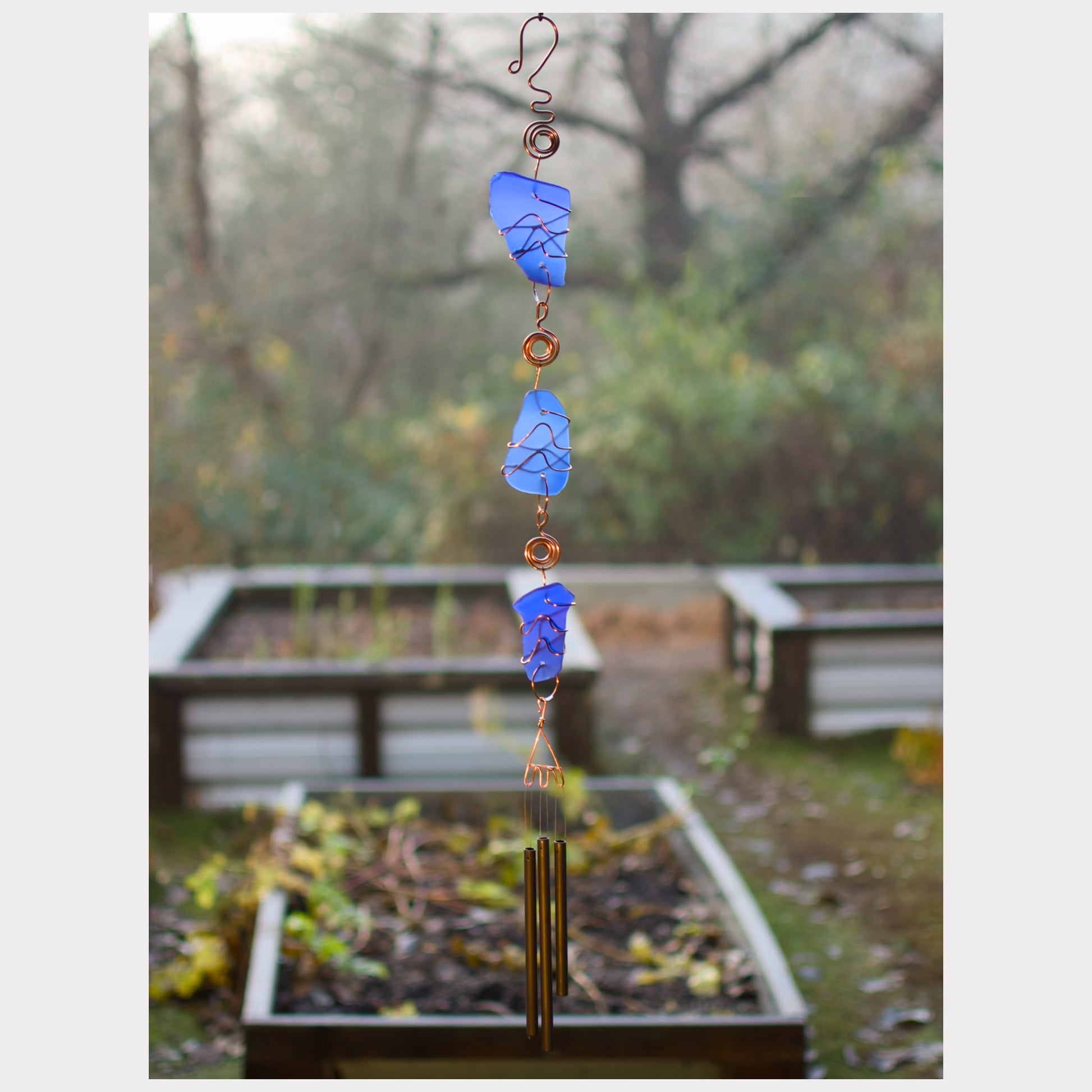 Fancy handcrafted cobalt blue beach glass wind chime with three antiqued brass chimes.