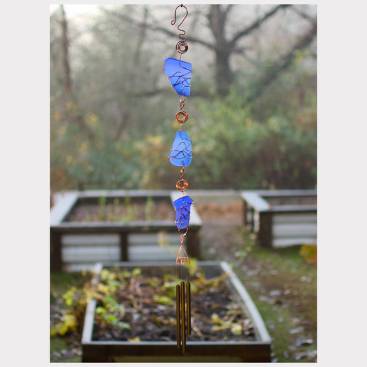 Fancy handcrafted cobalt blue beach glass wind chime with three antiqued brass chimes.