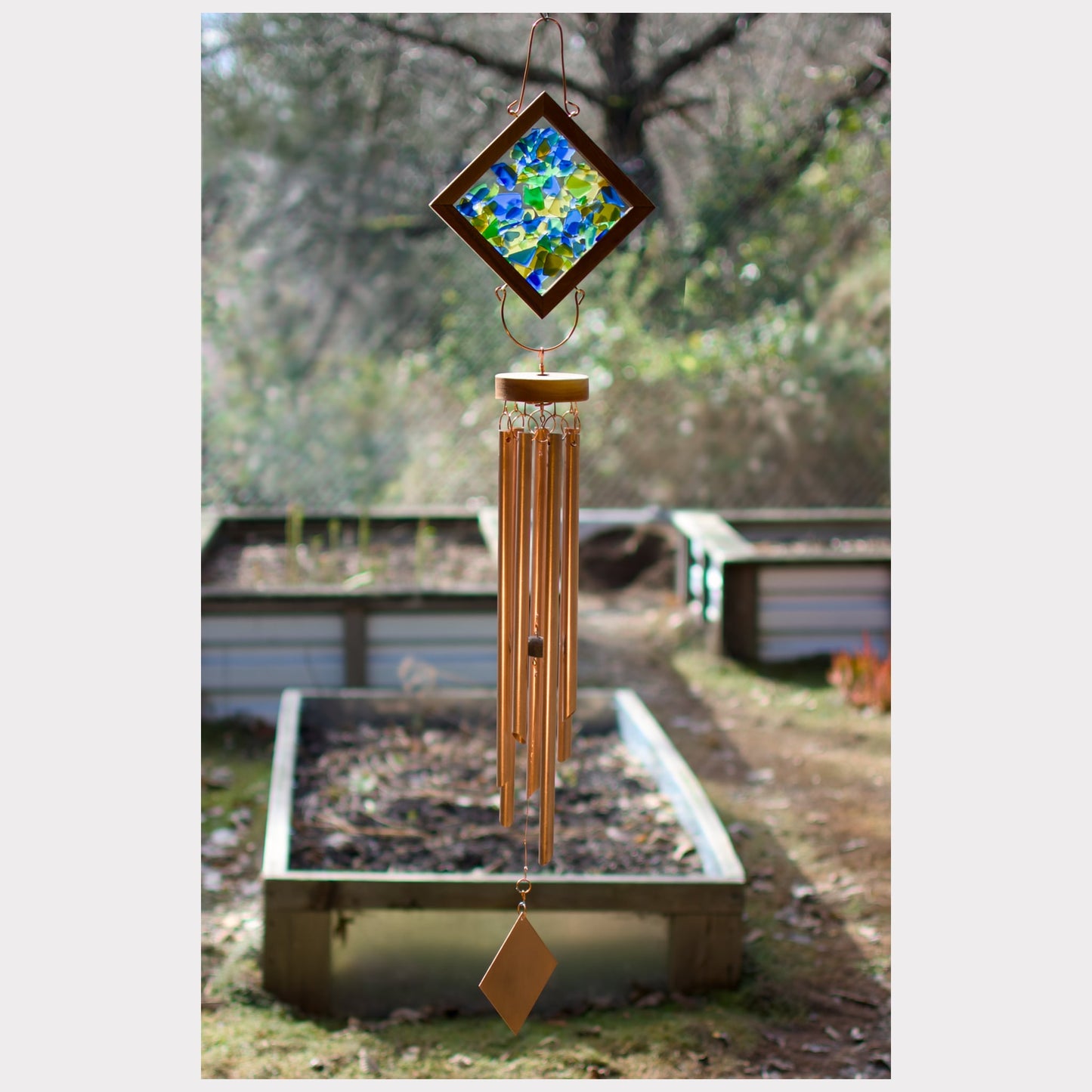 Large outdoor kaleidoscope wind chime featuring artist-made beach glass and seven copper chimes.