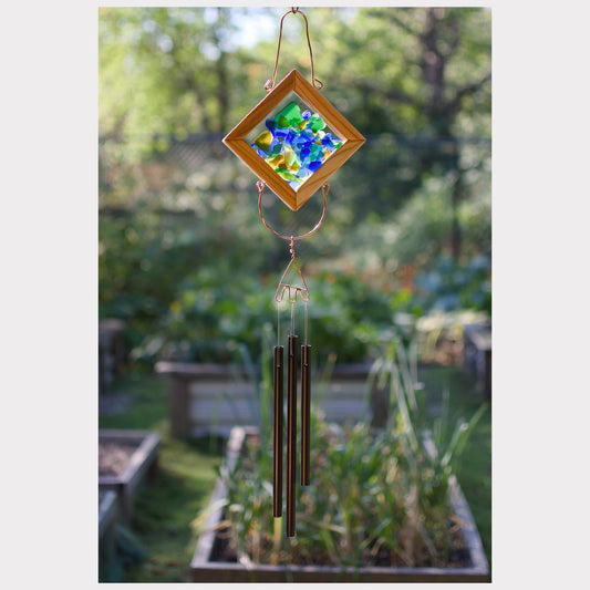 Decorative wind chime with colorful glass panel in a garden setting